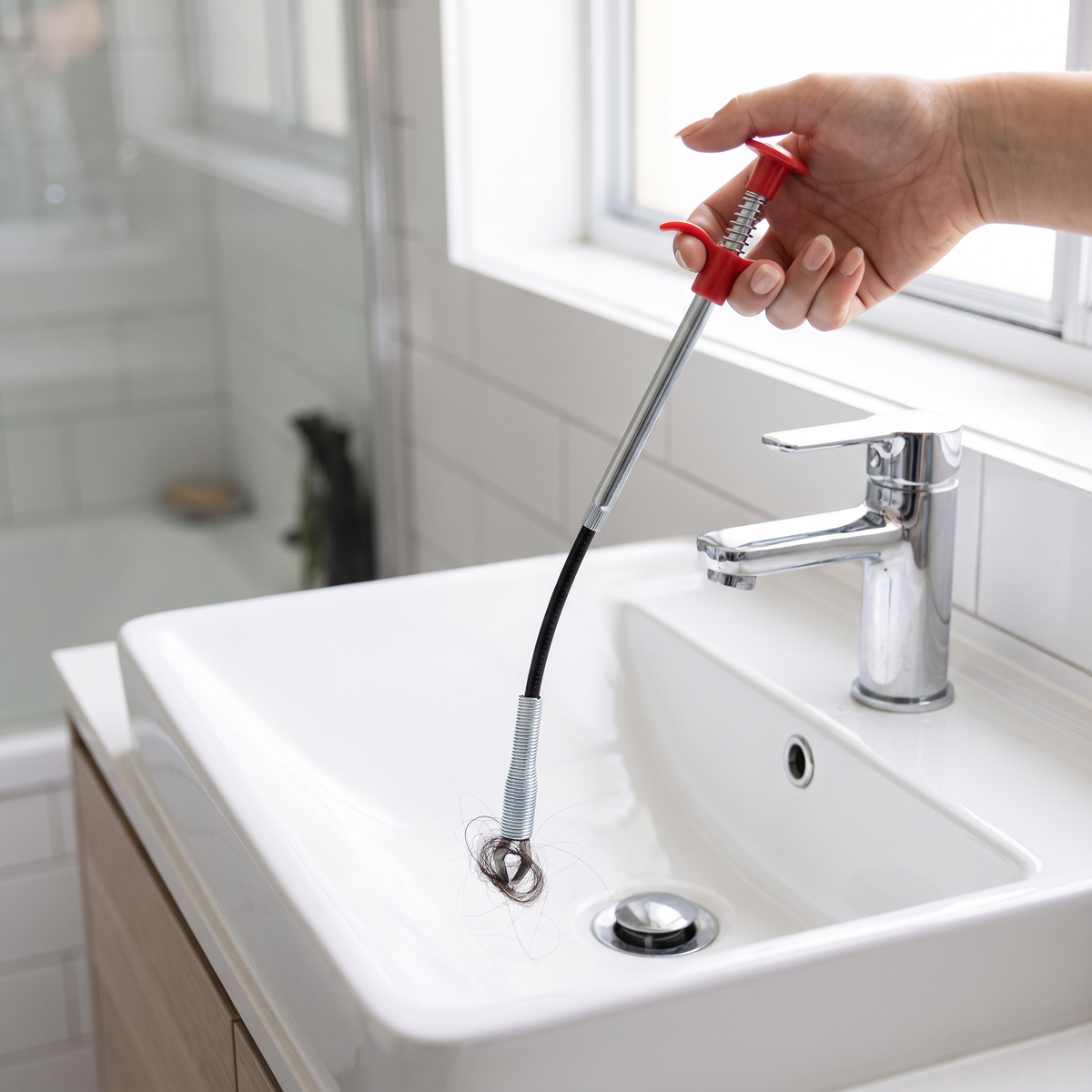 Roo Drain Snake clearing a blocked bathroom basin